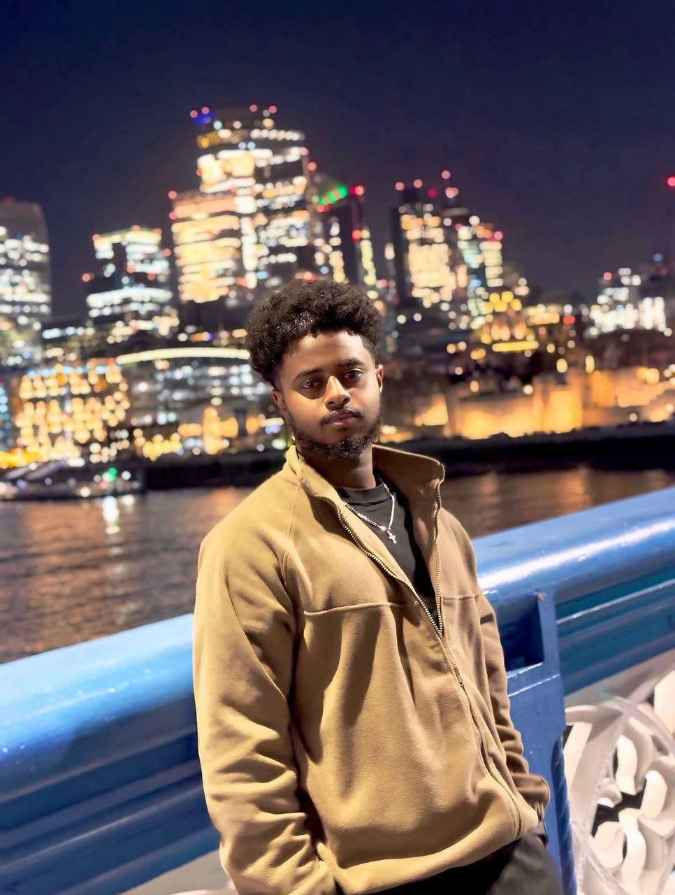 Portrait of Nahom Mekebib by a waterfront at night
